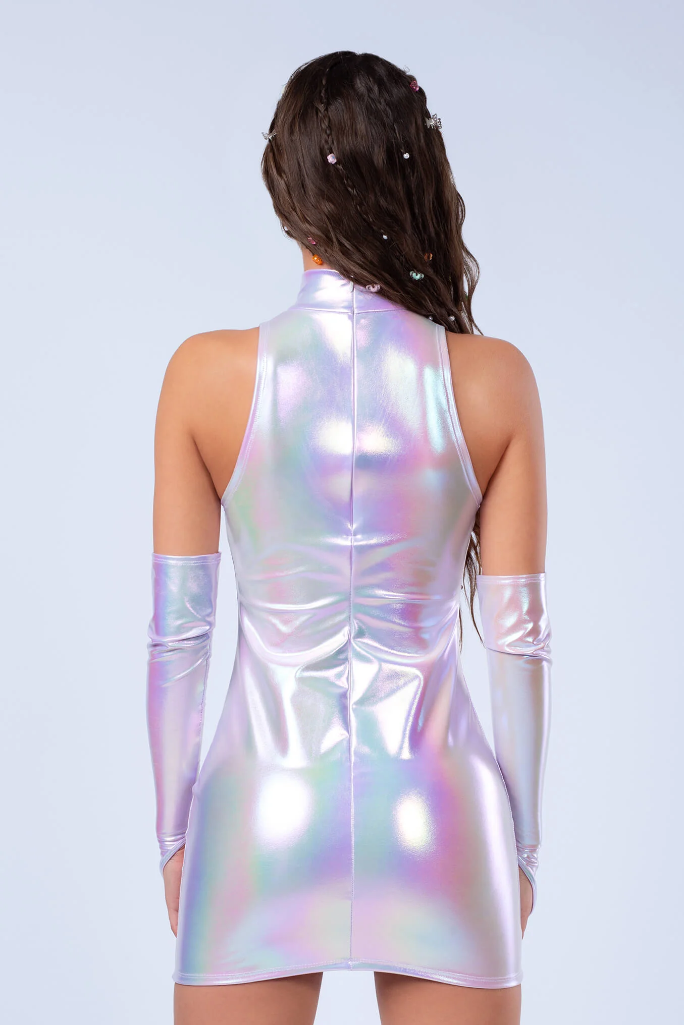 Frau im silbernen Hologramm Minikleid mit seitlicher Raffung, Herz-Cutout im Dekollté Bereich und Turtleneck