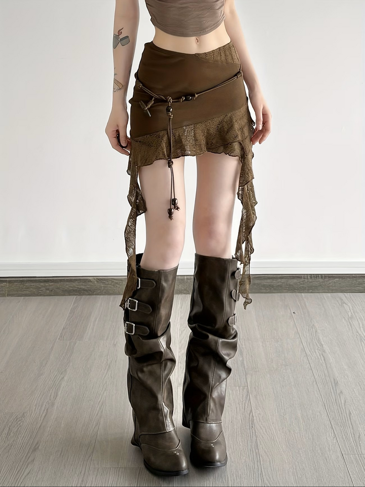 Nahaufnahme der unregelmäßigen Spitzendetails am braunen Minirock