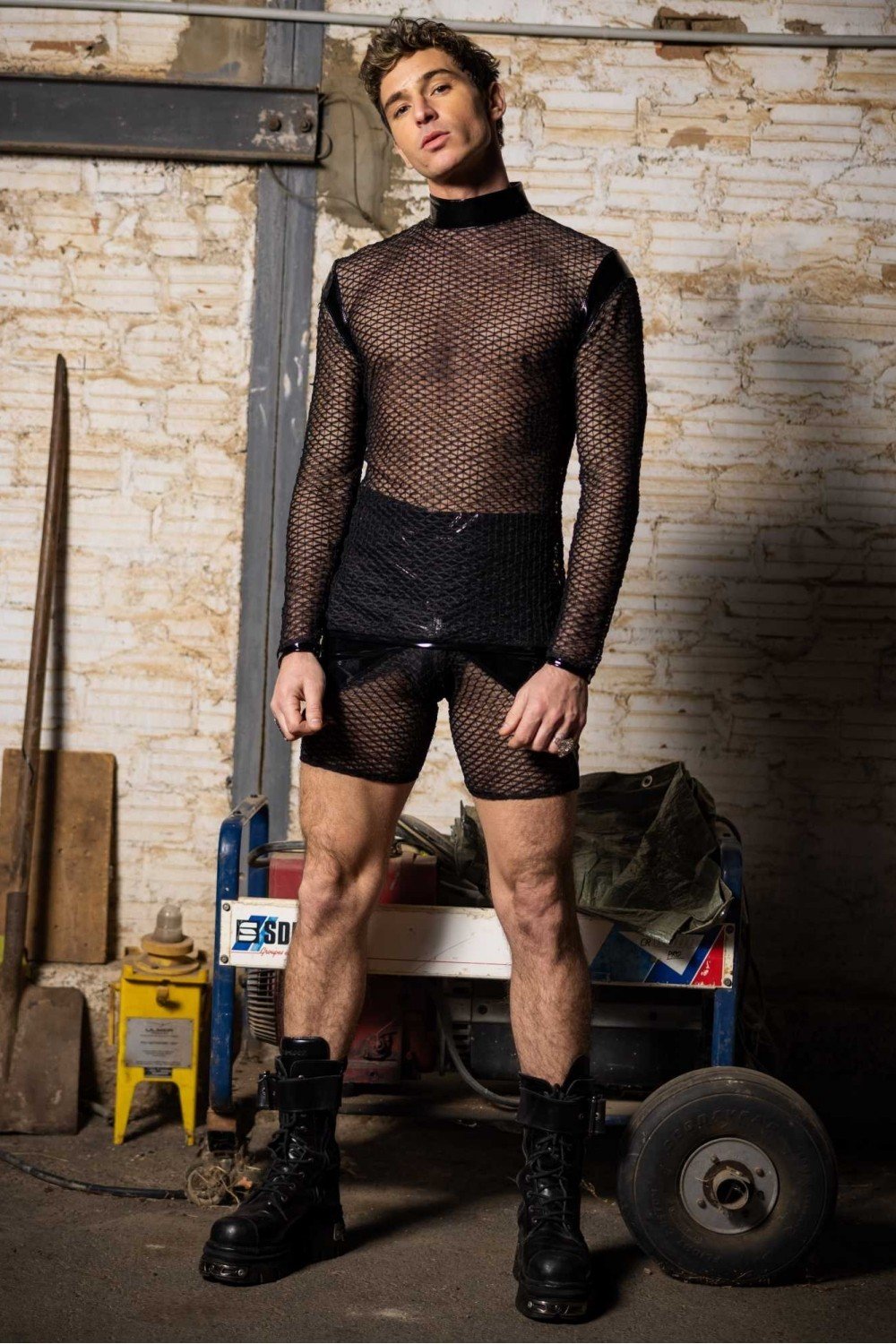 Die eng anliegende Patrice Catanzaro Leif Herren-Radlerhose aus glänzendem schwarzen Vinyl-Lackstoff mit transparenten Netzeinsätzen an der Vorderseite.