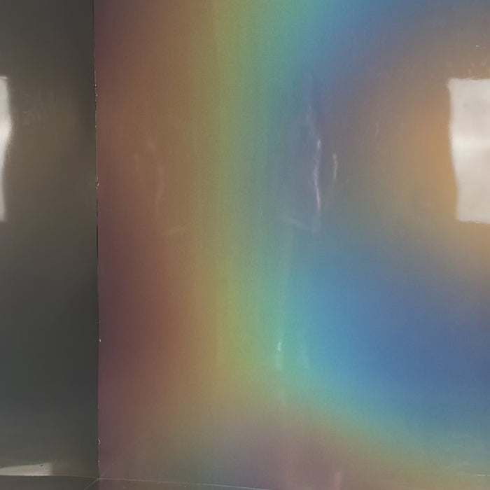 Frau im silbernen Hologramm Minikleid mit seitlicher Raffung, Herz-Cutout im Dekollté Bereich und Handschuhen