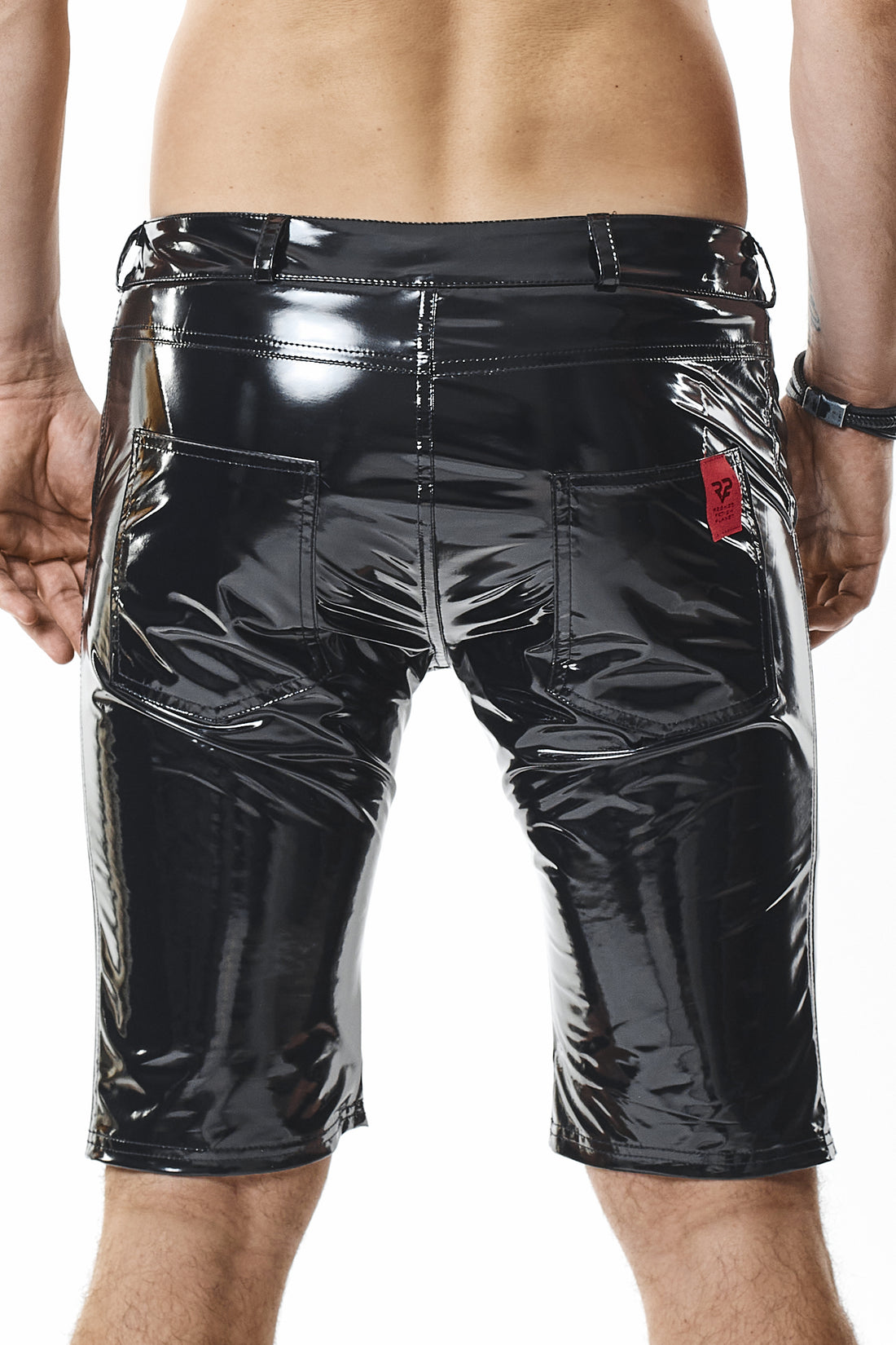 Frontalansicht der glänzenden Lack-Pants zeigt die Vordertaschen, Gürtelschlaufen und den Metallring rechts.